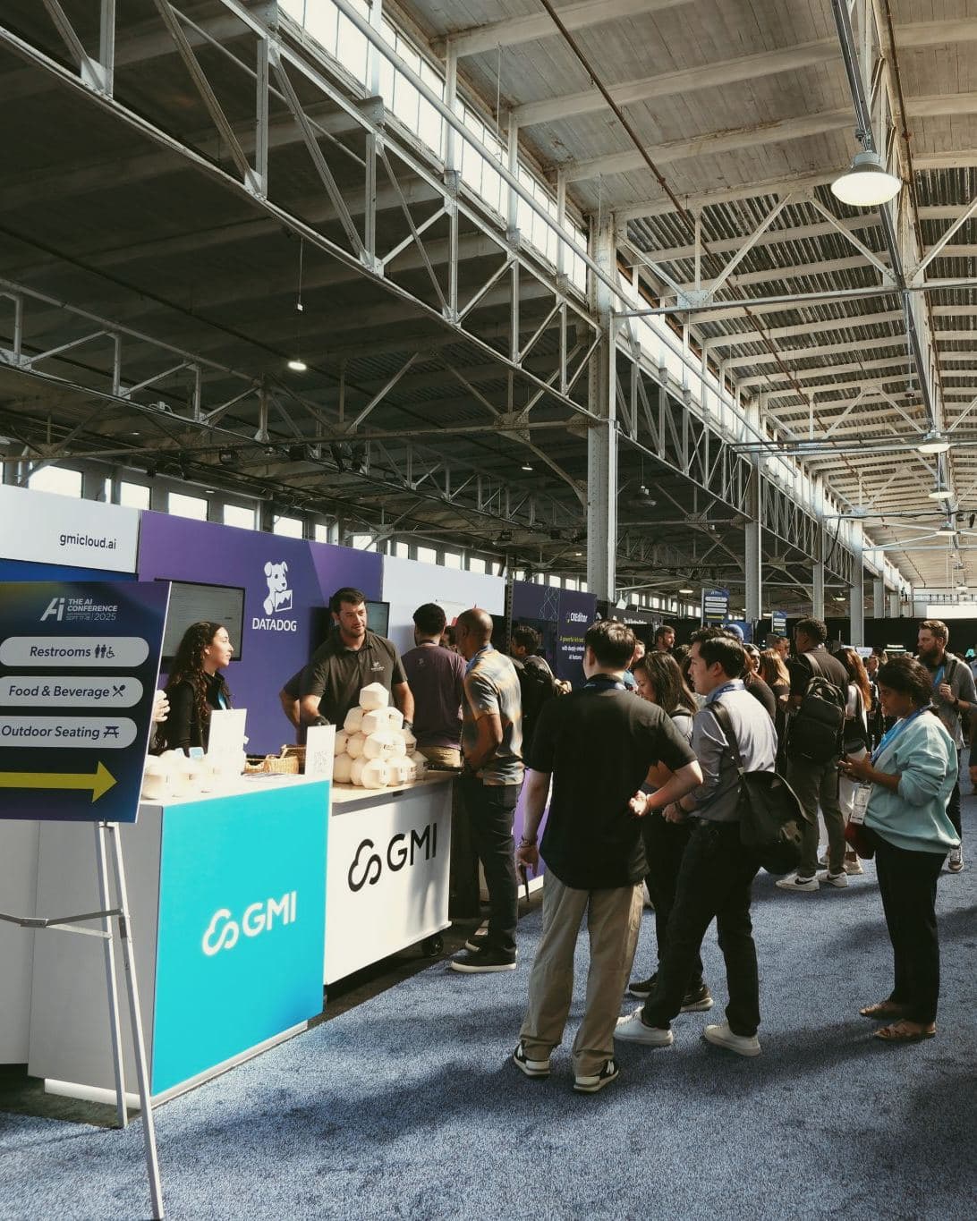 Line of attendees at the GMI Cloud booth serving stamped coconuts at The AI Conference