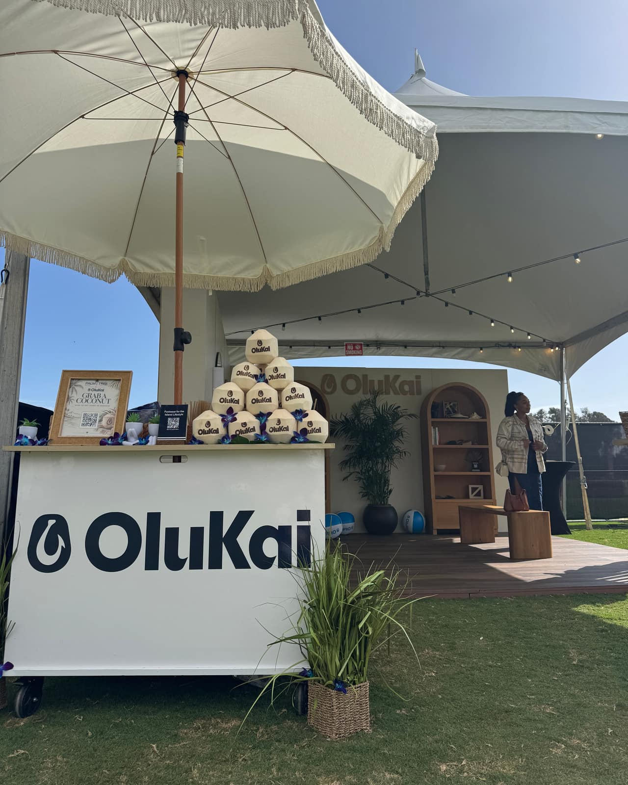 OluKai coconut cart with a Grab a Coconut QR sign at Palm Tree Music Festival