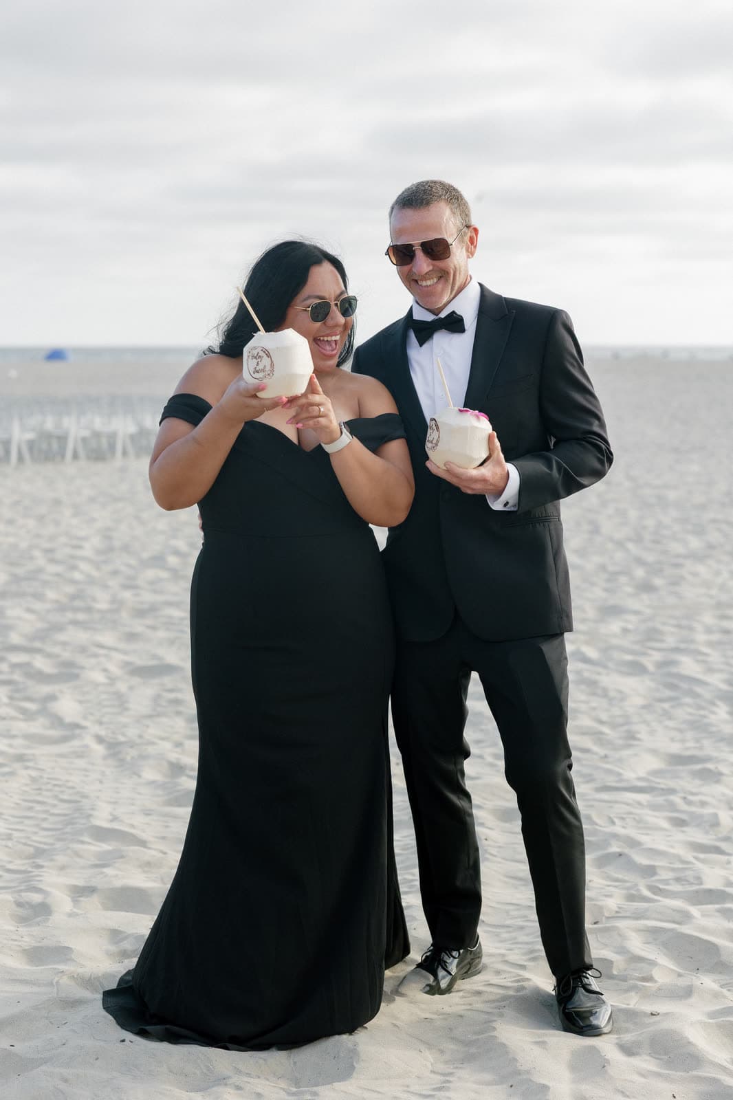 Guests in black tie on the beach with stamped coconuts