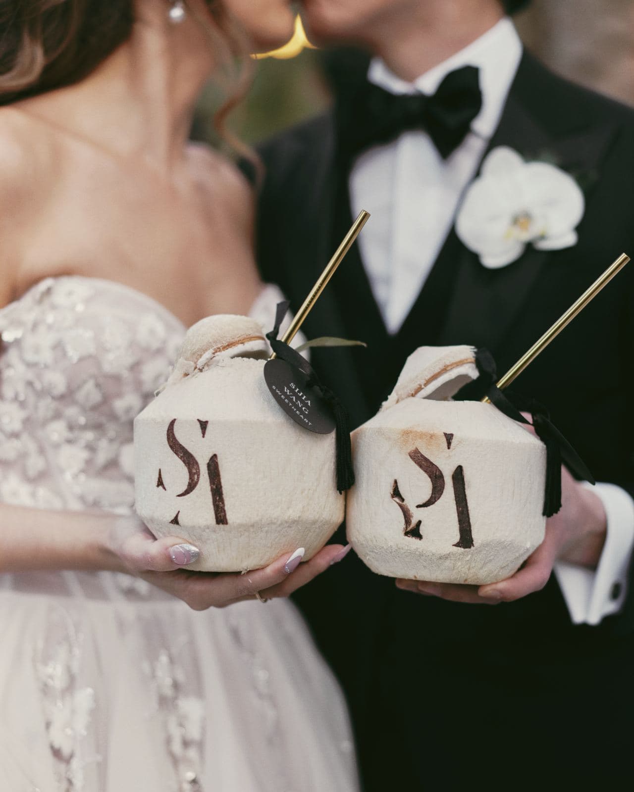 Bride and groom holding coconuts stamped with their monogram