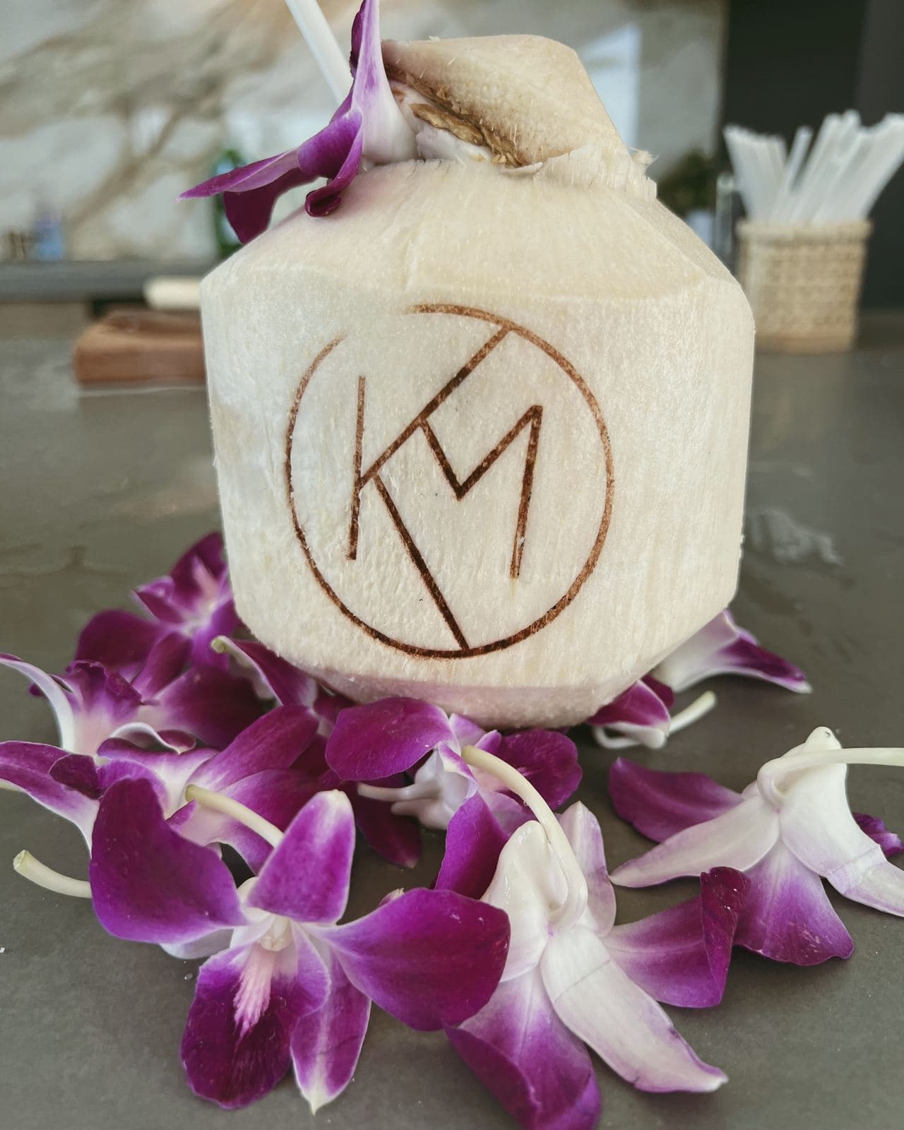 Monogrammed coconut with orchids at the reception bar
