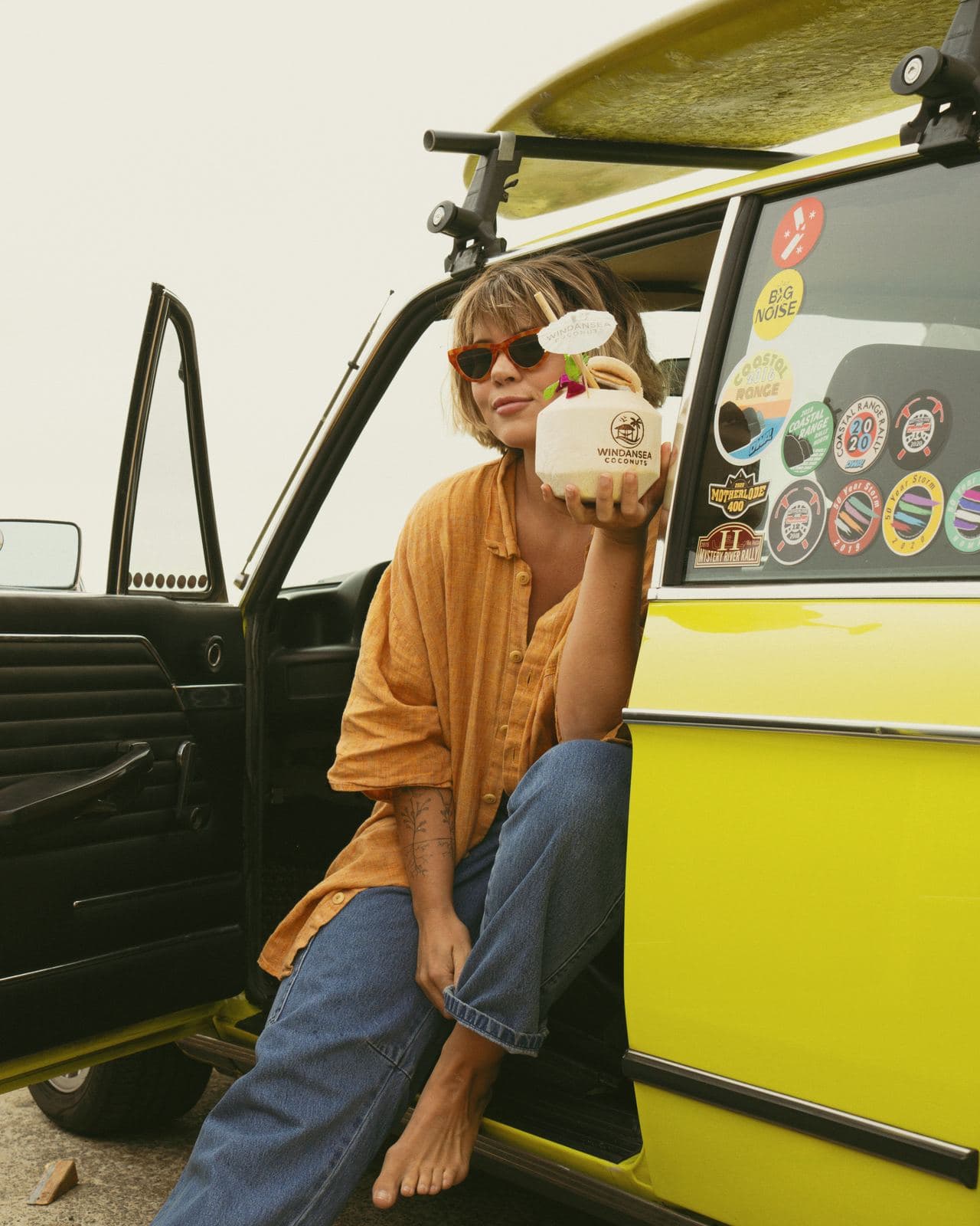 Woman in a yellow surf wagon holding a Windandsea-stamped coconut